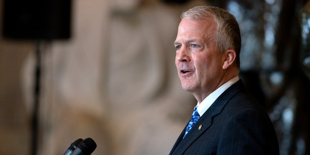 Senator Dan Sullivan (R-AK) gives a keepsake gives a keepsake of the late Representative Don Young (R-AK) while in the state of Statuary Hall at the United States Capitol on March 29, 2022 in Washington, DC. 