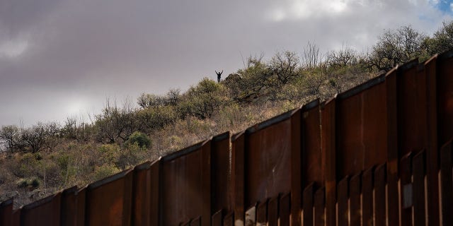 Migrants prepare to cross the U.S.-Mexico border in an area where the wall is not complete near Sasabe, Arizona, on Jan. 23, 2022.