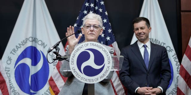 Transportation Secretary Pete Buttigieg looks at White House National Climate Adviser Gina McCarthy speaking at a fuel economy event at the Department of Transportation's April 1, 2022, Washington, DC
