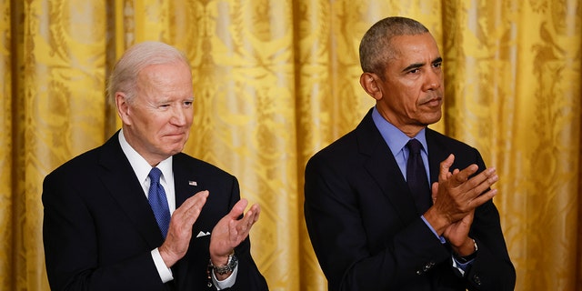 Biden, Obama clap at an event