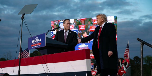 GOP Rep. Ted Budd, who is running for U.S. Senate, joins the stage with former President Donald Trump during a rally at The Farm at 95 on April 9, 2022 in Selma, North Carolina. 