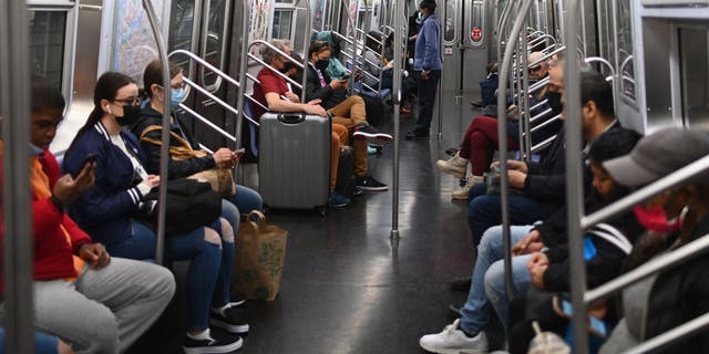 People commute on the subway in New York City on April 13, 2022, one day after people were injured during a rush-hour shooting in the Brooklyn borough of New York. 