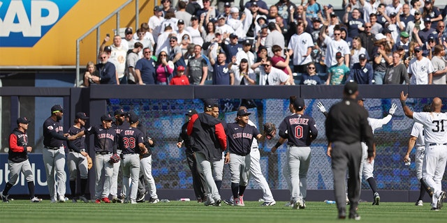 Members of the Cleveland Guardians react after fans throw debris on the field at Yankee Stadium on April 23, 2022, in New York. 