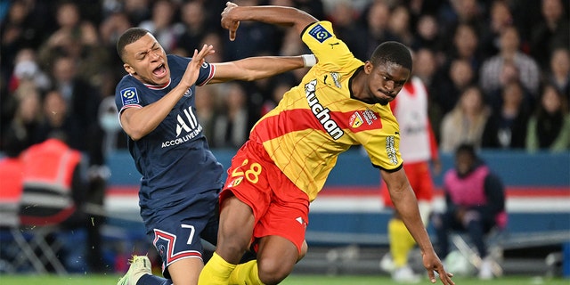 Kylian Mbappe, left, of Paris Saint-Germain in action against Cheick Doucoure of Lens during a French L1 soccer match at Parc des Princes stadium in Paris April 23, 2022.