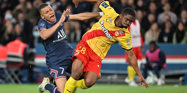 Kylian Mbappe, left, of Paris Saint-Germain in action against Cheick Doucoure of Lens during a French L1 soccer match at Parc des Princes stadium in Paris April 23, 2022.
