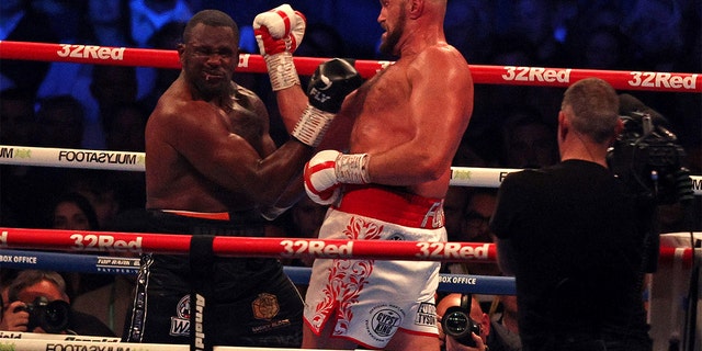 British Tyson Fury (R) lands a blow to knock out British Dillian Whyte in the sixth round and win their WBC heavyweight title fight at Wembley Stadium in west London on 23 April 2022. 