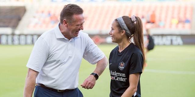 Houston Dash head coach James Clarkson smiles as he talks to Shea Groom # 6 in Houston Dash before a match between Portland Thorns FC and Houston Dash at BBVA Stadium on July 24, 2021 in Houston, Texas.