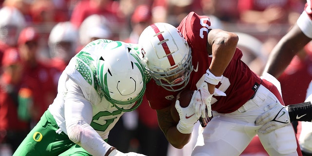 Austin Jones of the Stanford Cardinal is tackled by Kayvon Thibodeaux (5) of the Oregon Ducks at Stanford Stadium Oct. 2, 2021, in Stanford, Calif. 