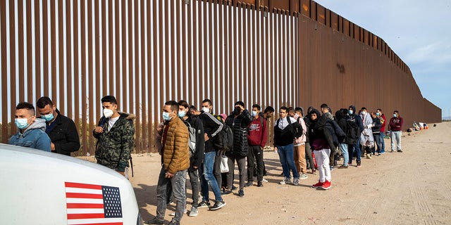 Immigrant men are taken into custody by U.S. Border Patrol agents at the U.S.-Mexico border Dec. 7, 2021, in Yuma, Ariz.