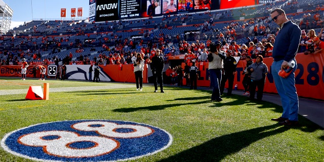 Former Denver Broncos player Peyton Manning (R) looks to the #88 logo on the field, in memory of his former Denver Broncos teammate Demaryius Thomas, before the game between the Detroit Lions and the Denver Broncos on December 9 at Empower Field At Mile High on December 12, 2021 in Denver, Colorado.