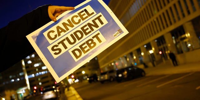 WASHINGTON, DC - MARCH 14: On the second anniversary of the student loan payment pause, We, The 45M, use signs and projections outside of the U.S. Department of Education to celebrate the pause and ask Education Secretary Cardona to cancel student debt on March 14, 2022 in Washington, D.C. (Photo by Paul Morigi/Getty Images for We The 45 Million)