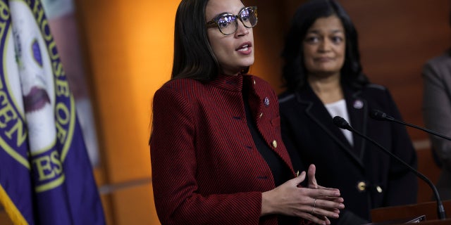 Alexandria Ocasio-Cortez (D-NY) (L), joined by Rep. Pramila Jayapal (D-WA), speaks at a news conference on banning stock trades for members of Congress, on Capitol Hill, April 07, 2022 in Washington, DC. Lawmakers have introduced the, Ban Conflicted Trading Act, which would prohibit members of Congress and senior staff from purchasing and selling individual stocks or serving on the board of a for-profit company
