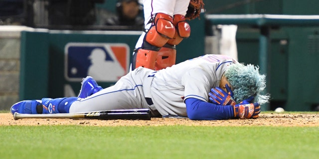 Francisco Lindor #12 of the New York Mets lies on the ground after getting by a pitch in the fifth inning during a baseball game against the Washington Nationals at the Nationals Park on April 8, 2022, in Washington, DC.