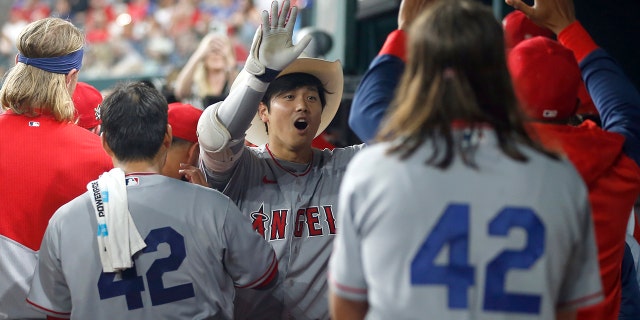 Shohei Ohtani (center) of the Los Angeles Angels is congratulated after hitting a home run in the fifth inning against the Texas Rangers at Globe Life Field April 15, 2022 in Arlington, Texas.