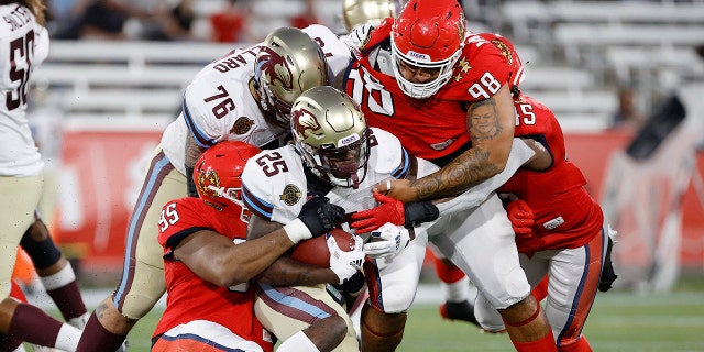 Stevie Scott III #25 of Michigan Panthers is tackled by New Jersey Generals defensemen in the first quarter of the game at Protective Stadium on April 22, 2022 in Birmingham, Alabama. 