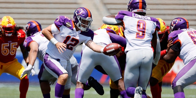 Josh Love # 12 of the Pittsburgh Maulers delivers the ball to Madre London # 9 in the fourth quarter of the match against the Philadelphia Stars at the Protective Stadium on April 23, 2022 in Birmingham, Alabama.