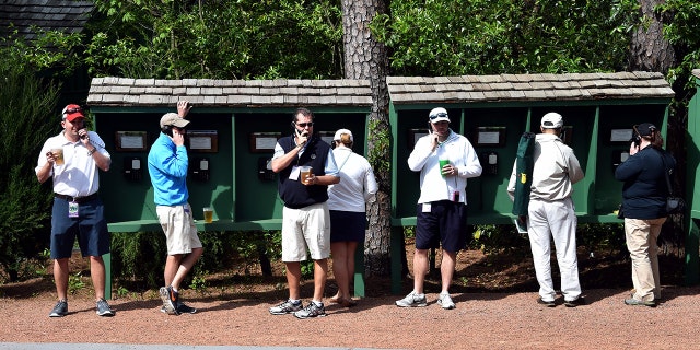 Patrons make phone calls during a practice round before the 80th Masters on April 6, 2016, in Augusta, Georgia.