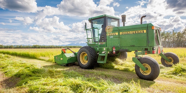 A self-propelled disc mower is shown cutting a field of hay (grass). (Photo by Edwin Remsburg/VW Pics via Getty Images)