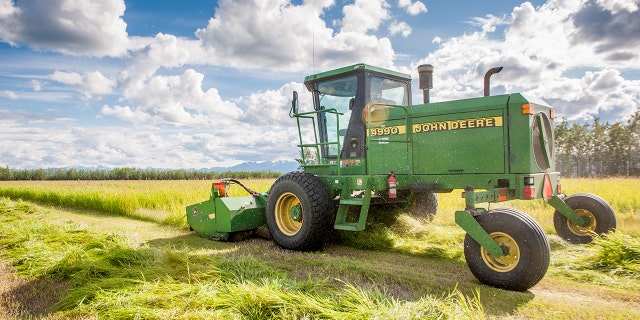 A self-propelled disc mower is shown cutting a field of hay (grass). (Photo by Edwin Remsburg/VW Pics via Getty Images)