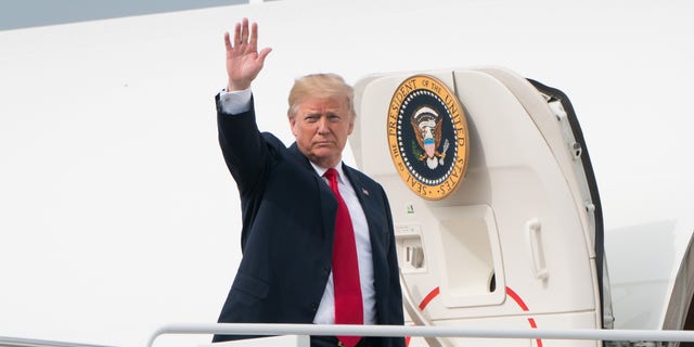 President Donald Trump waves while boarding Air Force One at Joint Base Andrews.