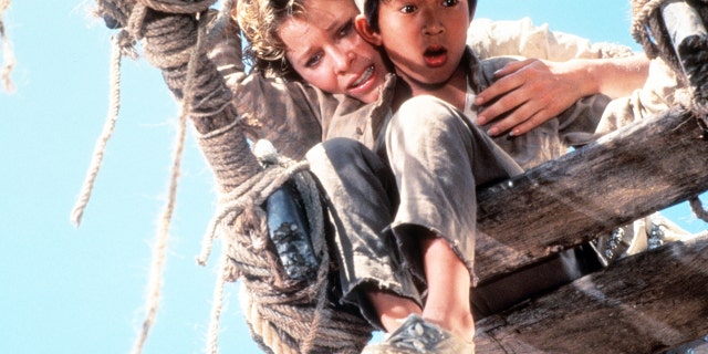 Kate Capshaw holds Ke Huy Quan to a broken bridge in a scene from the film "Indiana Jones and the Temple of Doom."