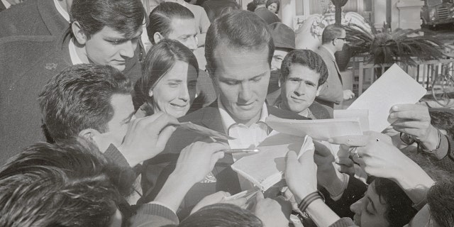 Autograph-hungry fans besiege American singer Pat Boone. The entertainer was a teen idol during the ‘50s and '60s.