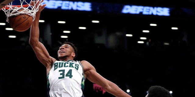 Milwaukee Bucks forward Giannis Antetokounmpo (34) dunks as Brooklyn Nets Kevin Durant (7) and Kyrie Irving watch during the first half of an NBA basketball game Thursday, 行進 31, 2022, ニューヨークで.