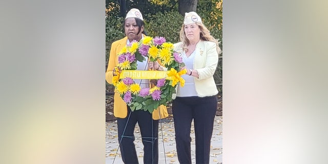Tamra Sipes (at right) and another Gold Star Wife are shown laying a wreath at Arlington National Cemetery, at the Tomb of the Unknown Soldier, on Veterans Day in 2021.