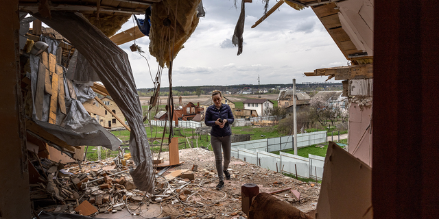 A local resident is shown walking through the destroyed second floor of her multi-generational home while searching for salvageable items in April, in Hostomel, Ukraine, outside the city of Kyiv.