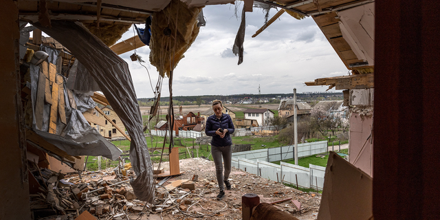 A local resident is shown walking through the destroyed second floor of her multi-generational home while searching for salvageable items in April, in Hostomel, Ukraine, outside the city of Kyiv.