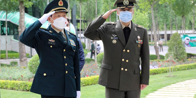 In this picture released by the official website of the Iranian Defense Ministry, China's minister of national defense Gen. Wei Fenghe, left, is welcomed by Iran's defense minister Gen. Mohammad Reza Ashtiani, during an official welcoming ceremony, in Tehran, Iran, Wednesday, April 27, 2022.