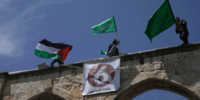 Protesters wave the Palestinian and Hamas flags after Friday prayers during the Muslim holy month of Ramadan, hours after Israeli police clashed with protesters at the Al Aqsa Mosque compound in Jerusalem's Old City Friday, April 22, 2022.