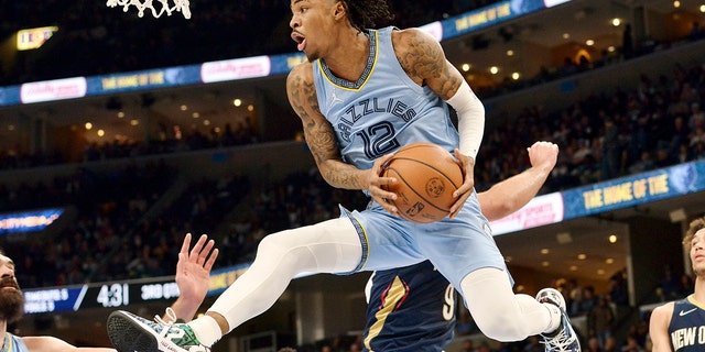 Memphis Grizzlies guard Ja Morant (12) handles the ball under the basket during the second half of the team's NBA basketball game against the New Orleans Pelicans onSaturday, April 9, 2022, in Memphis, Tenn.