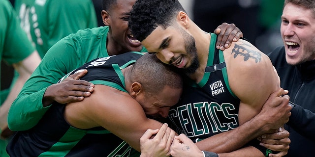 Boston Celtics center Al Horford, front left, and forward Jayson Tatum, front right, celebrate after Tatum made a layup at the buzzer to score and win Game 1 of an NBA basketball first-round Eastern Conference playoff series against the Brooklyn Nets, Sunday, April 17, 2022, in Boston. The Celtics won 115-114.