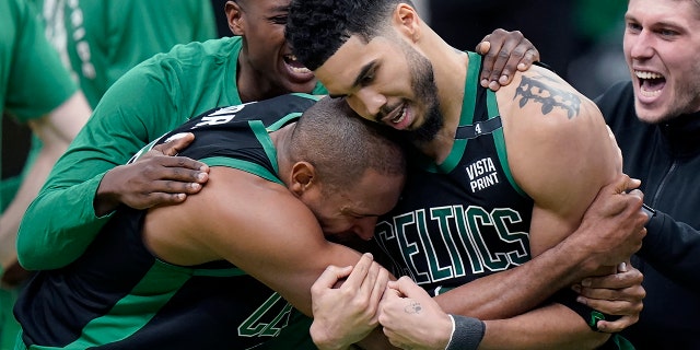 Boston Celtics center Al Horford, front left, and forward Jayson Tatum, front right, celebrate after Tatum made a layup at the buzzer to score and win Game 1 of an NBA basketball first-round Eastern Conference playoff series against the Brooklyn Nets, Sunday, April 17, 2022, in Boston. The Celtics won 115-114.