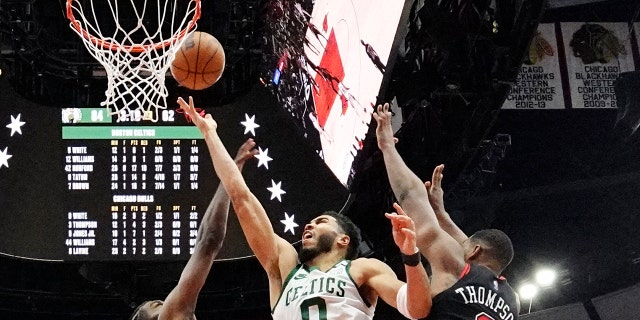 جیسون تیتوم، مهاجم بوستون سلتیکس (0) در نیمه دوم یک بازی بسکتبال NBA در شیکاگو، چهارشنبه، 6 آوریل 2022، در مقابل پاتریک ویلیامز، مهاجم شیکاگو بولز، پاتریک ویلیامز، مهاجم شیکاگو بولز، تریستان تامپسون چپ و مرکز سبد برتری دارد. سلتیکس با نتیجه 117-94 پیروز می شود.