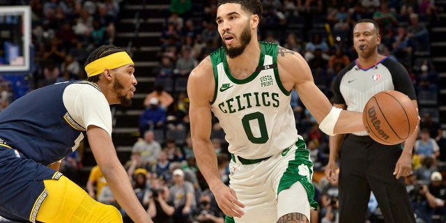 Boston Celtics forward Jayson Tatum (0) handles the ball against Memphis Grizzlies guard Ziaire Williams in the second half of an NBA basketball game Sunday, April 10, 2022, in Memphis, Tenn. 