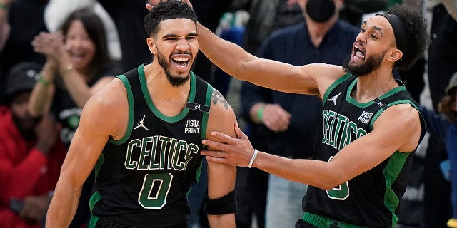 Boston Celtics forward Jayson Tatum (0) celebrates with guard Derrick White (9) after making a layup at the buzzer to score and win Game 1 of an NBA basketball first-round Eastern Conference playoff series against the Brooklyn Nets, Sunday, April 17, 2022, in Boston. The Celtics won 115-114.