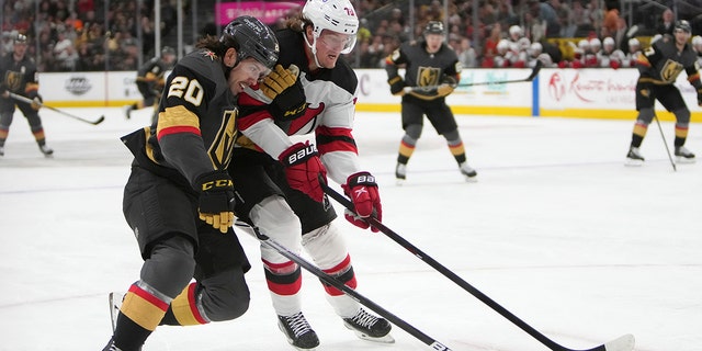 Vegas Golden Knights center Chandler Stephenson (20) and New Jersey Devils center Jesper Boqvist (70) vie for the puck during the second period of an NHL hockey game Monday, 4月 18, 2022, ラスベガスで.