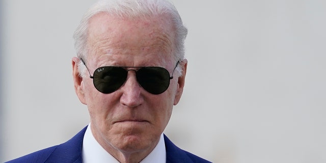 President Biden walks toward reporters.