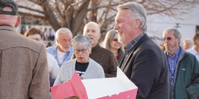 Republican Senate candidate Joe O'Dea hands out doughnuts to voters outside the state GOP assembly, on April 9, 2022, in Colorado Springs, Colorado.