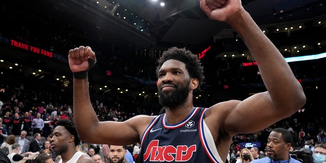Philadelphia 76ers' Joel Embiid celebrates as Toronto Raptors forward OG Anunoby, links, walks past after Game 6 of an NBA basketball first-round playoff series Thursday, April 28, 2022, in Toronto.