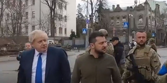 Left, U.K. Prime Minister Boris Johnson, and Ukrainian President Volodymyr Zelenskyy walk down the streets of Kyiv. 