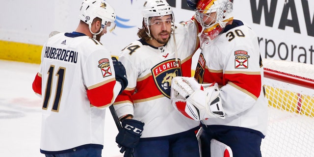 Florida Panthers left wing Jonathan Huberdeau (11) and left wing Ryan Lomberg (94) celebrate a victory with goaltender Spencer Knight (30) following the third period of an NHL hockey game against the Buffalo Sabres, 日曜日, 4月 3, 2022, in Buffalo, N.Y.