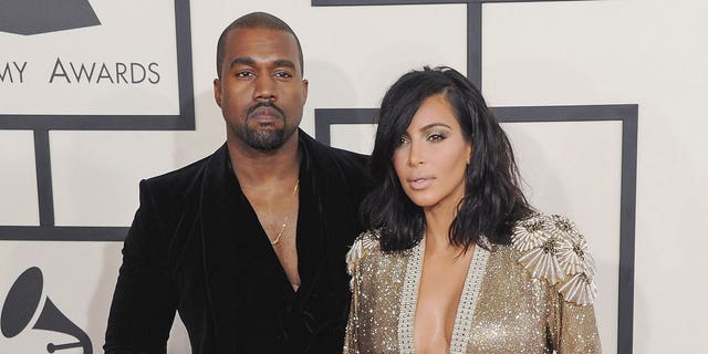 Kanye West and Kim Kardashian pose for a photo