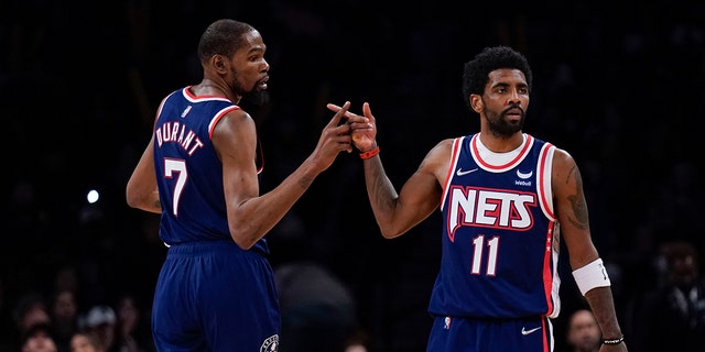 Brooklyn Nets' Kyrie Irving, right, and Kevin Durant celebrate after a basket against the Indiana Pacers at the Barclays Center, Sunday, April 10, 2022, in New York.