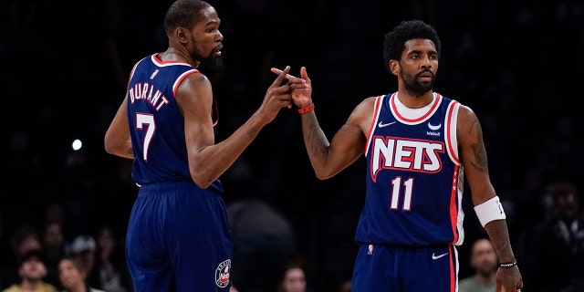 Brooklyn Nets' Kyrie Irving, right, and Kevin Durant celebrate after a basket during a game against the Indiana Pacers at Barclays Center on April 10, 2022 in New York City. 