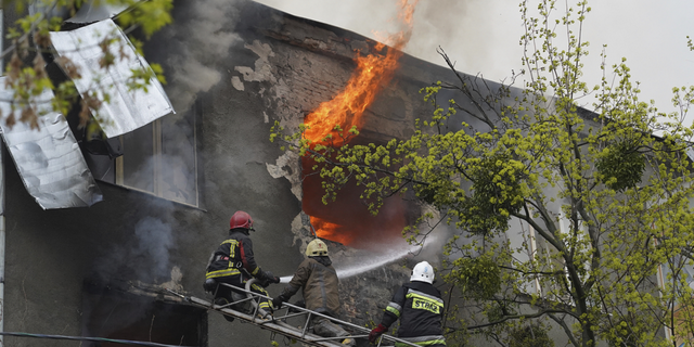 Firefighters work to extinguish fire at an apartments building after a Russian attack in Kharkiv, Ukraine, on Sunday.