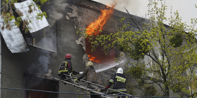 Firefighters work to extinguish fire at an apartments building after a Russian attack in Kharkiv, Ukraine, on Sunday.
