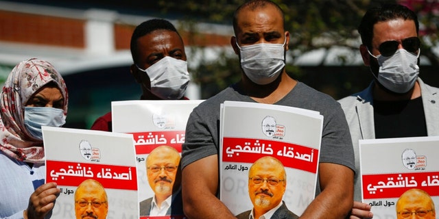 FILE - People hold posters of slain Saudi journalist Jamal Khashoggi, near the Saudi Arabia consulate in Istanbul, marking the two-year anniversary of his death, Oct. 2, 2020. A Turkish court ruled Thursday, April 7, 2022 to suspend the trial in absentia of 26 Saudis accused in the gruesome killing of Washington Post columnist Jamal Khashoggi and for the case to be transferred to Saudi Arabia.